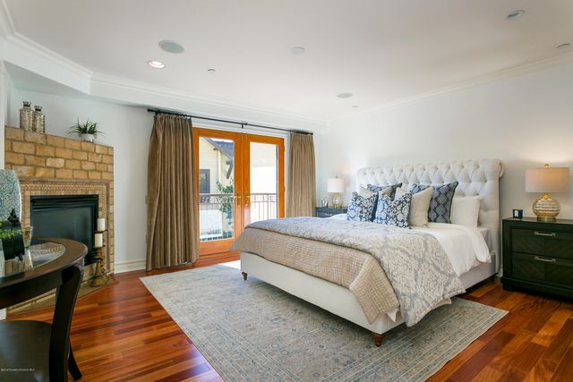 a large bedroom with a bed and wooden floor