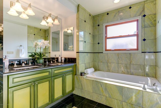 a bathroom with a sink mirror and a bathtub