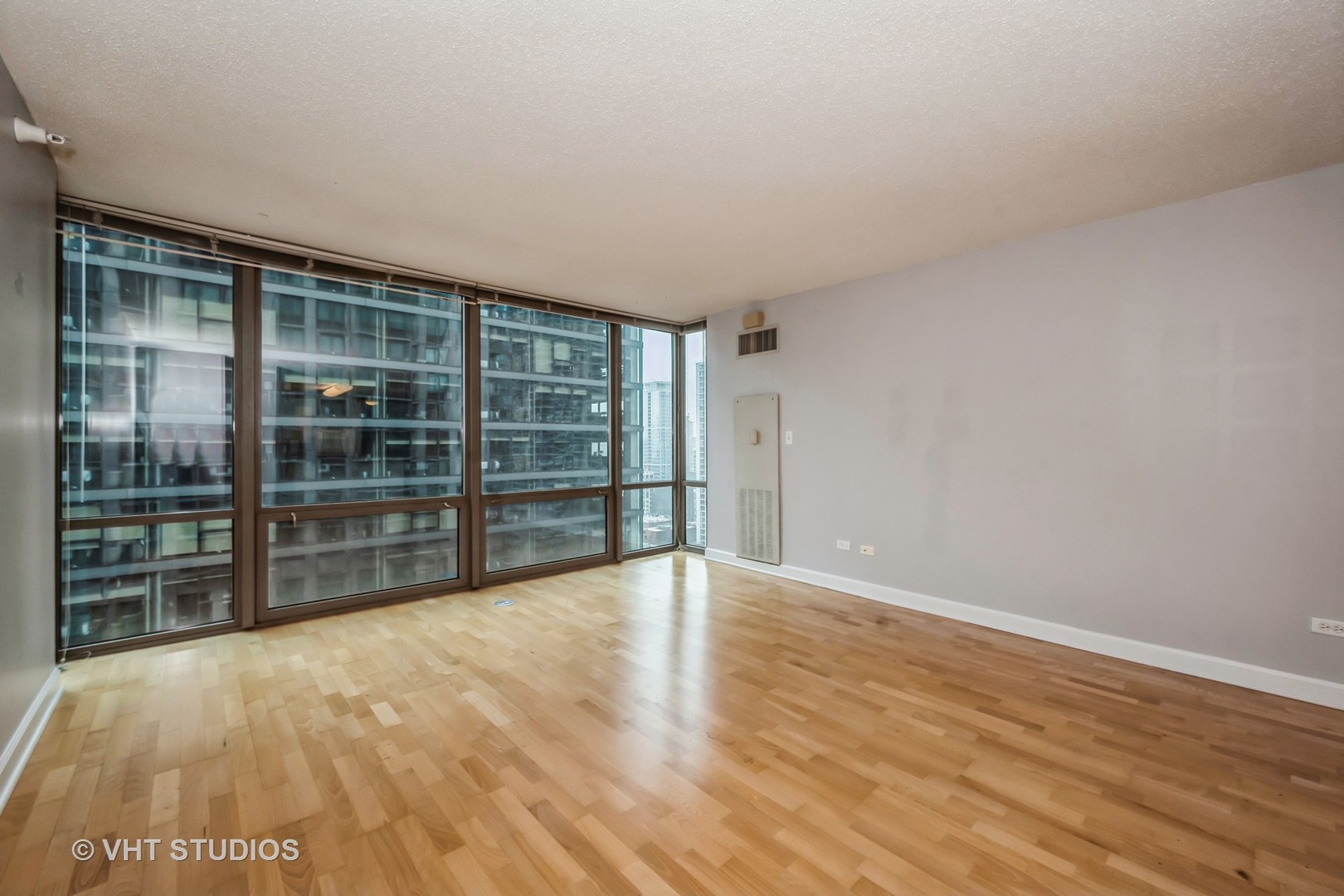 2 East Erie Street, Unit 1606 Chicago, IL 60611 - Photo 5 of 13 a view of empty room with wooden floor and floor to ceiling window