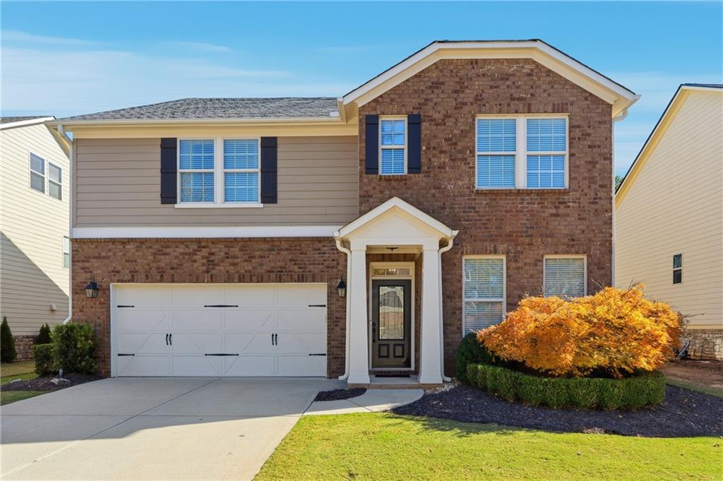 a front view of a house with a yard and garage