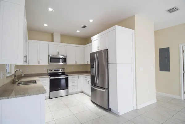a kitchen with granite countertop a refrigerator and a sink