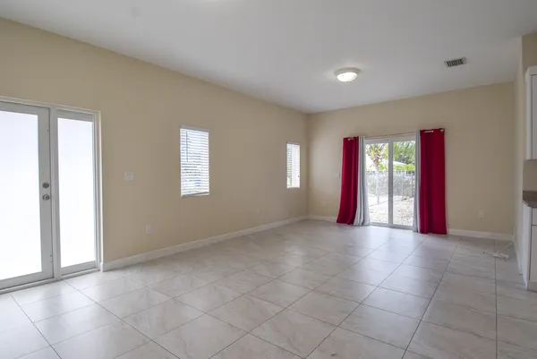 a view of an empty room with windows and closet area