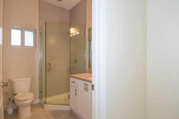 a bathroom with a granite countertop toilet a sink and a mirror