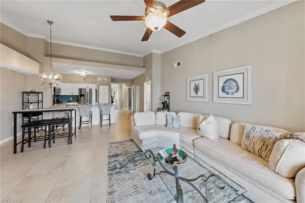 a living room with furniture kitchen view and a wooden floor