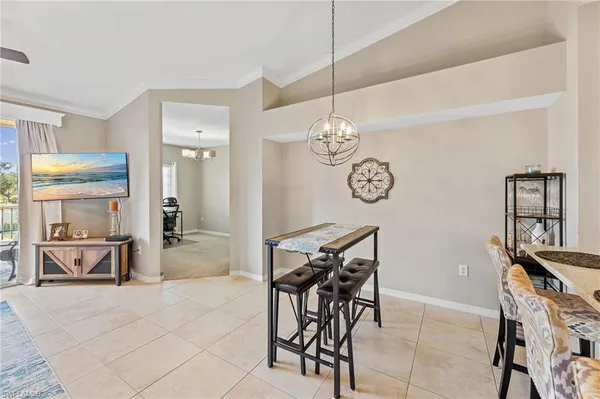 a view of a dining room with furniture a chandelier and kitchen view