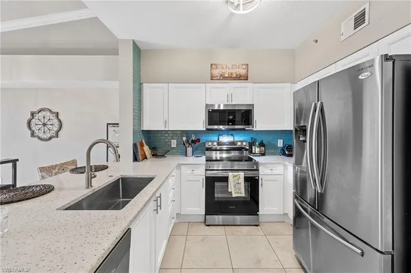 a kitchen with stainless steel appliances granite countertop a refrigerator sink and stove