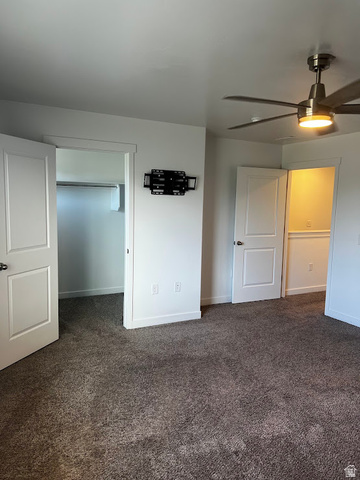 562 Hal Street, Unit 152 Tooele, UT 84074 - Photo 20 of 44 Plush dark gray carpeting extending throughout, white paneled doors, modern ceiling fan with integrated lighting, and a wall-mounted television bracket