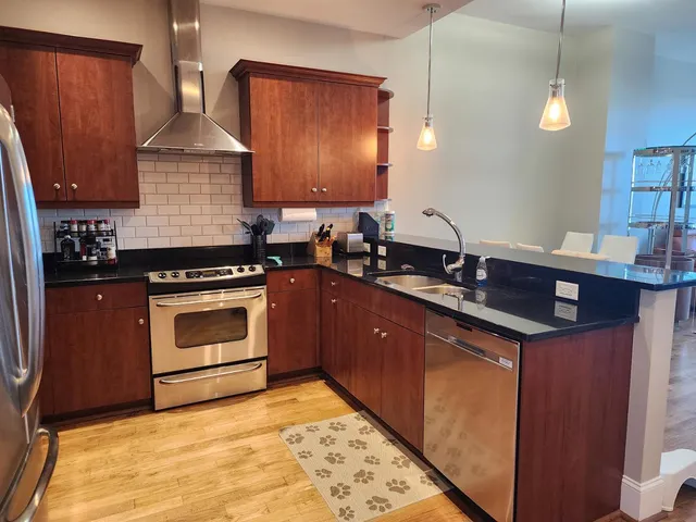 a kitchen with a refrigerator a counter top space and stainless steel appliances