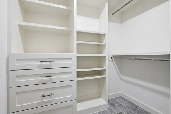 a view of walk in closet with empty racks