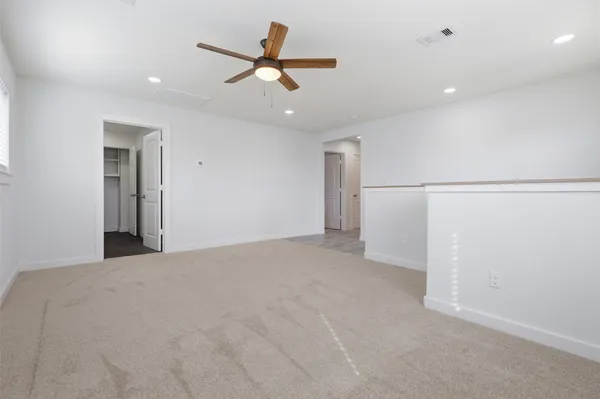a view of a livingroom with a ceiling fan and refrigerator