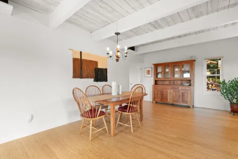 a balcony with wooden floor table and chairs