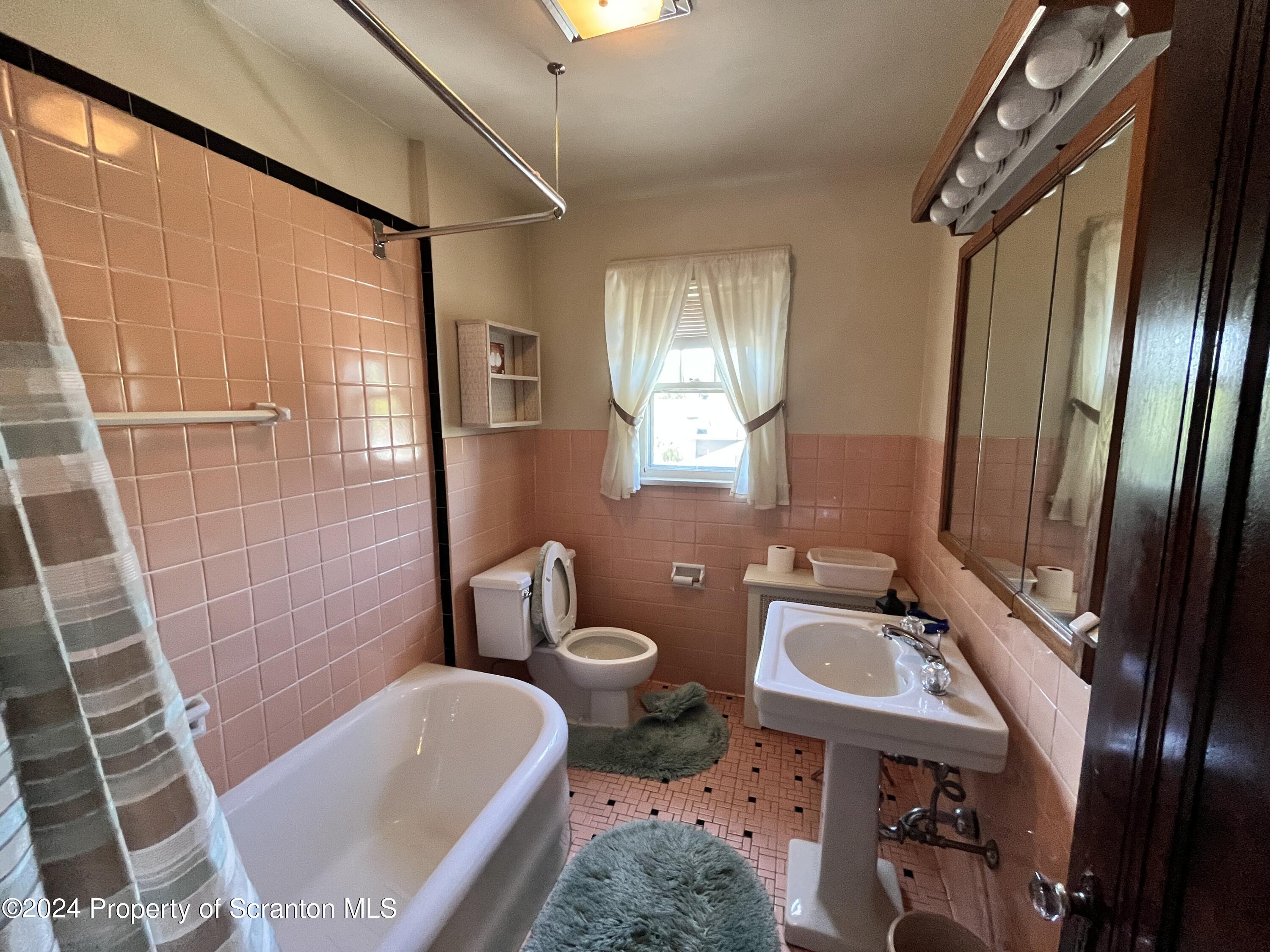 2002 Green Ridge Street Dunmore, PA 18512 - Photo 26 of 43 a bathroom with a sink a toilet a mirror and shower