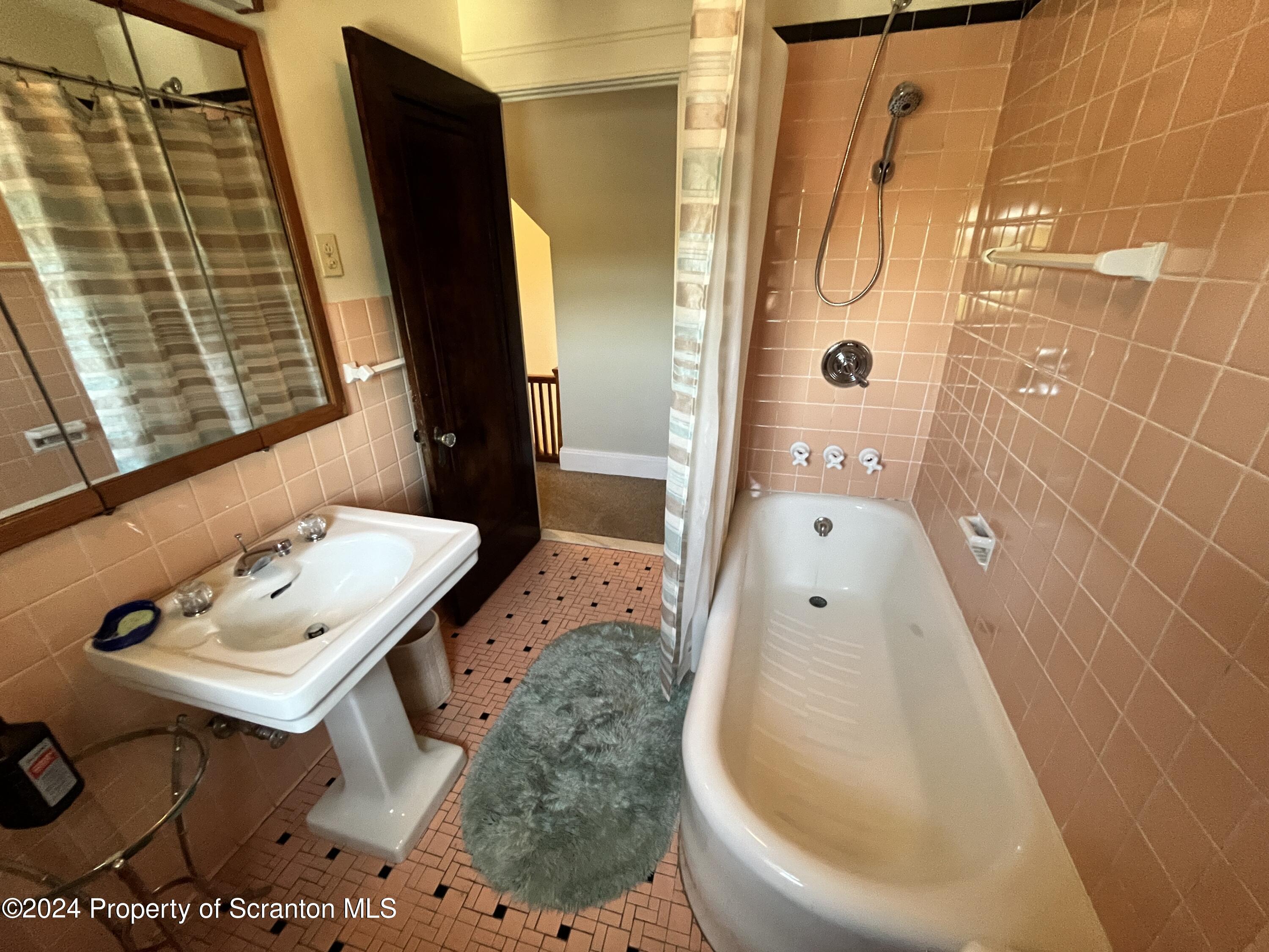 2002 Green Ridge Street Dunmore, PA 18512 - Photo 28 of 43 a bathroom with a sink and mirror with bathtub