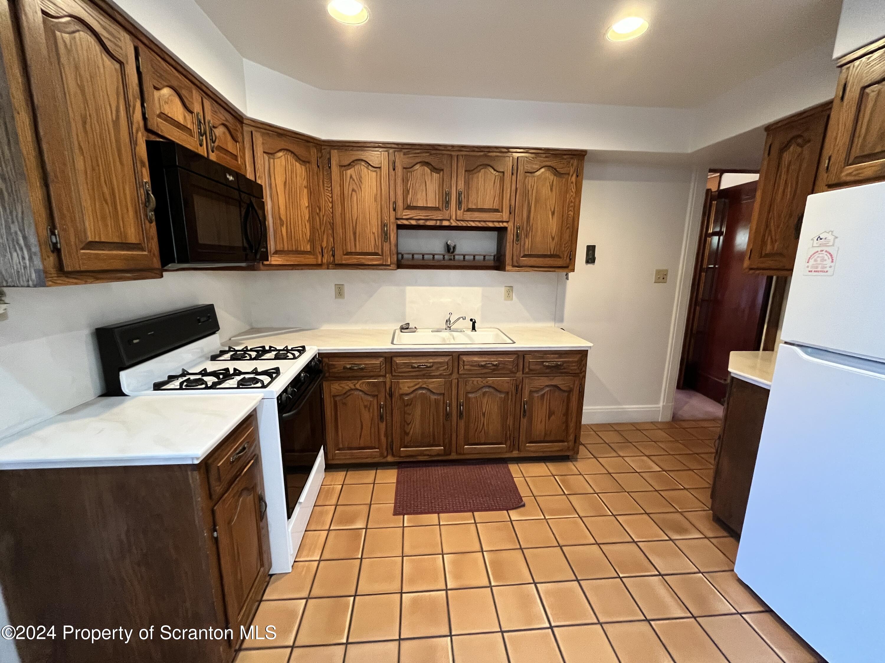 2002 Green Ridge Street Dunmore, PA 18512 - Photo 4 of 43 a kitchen with a sink a stove top oven a refrigerator and cabinets