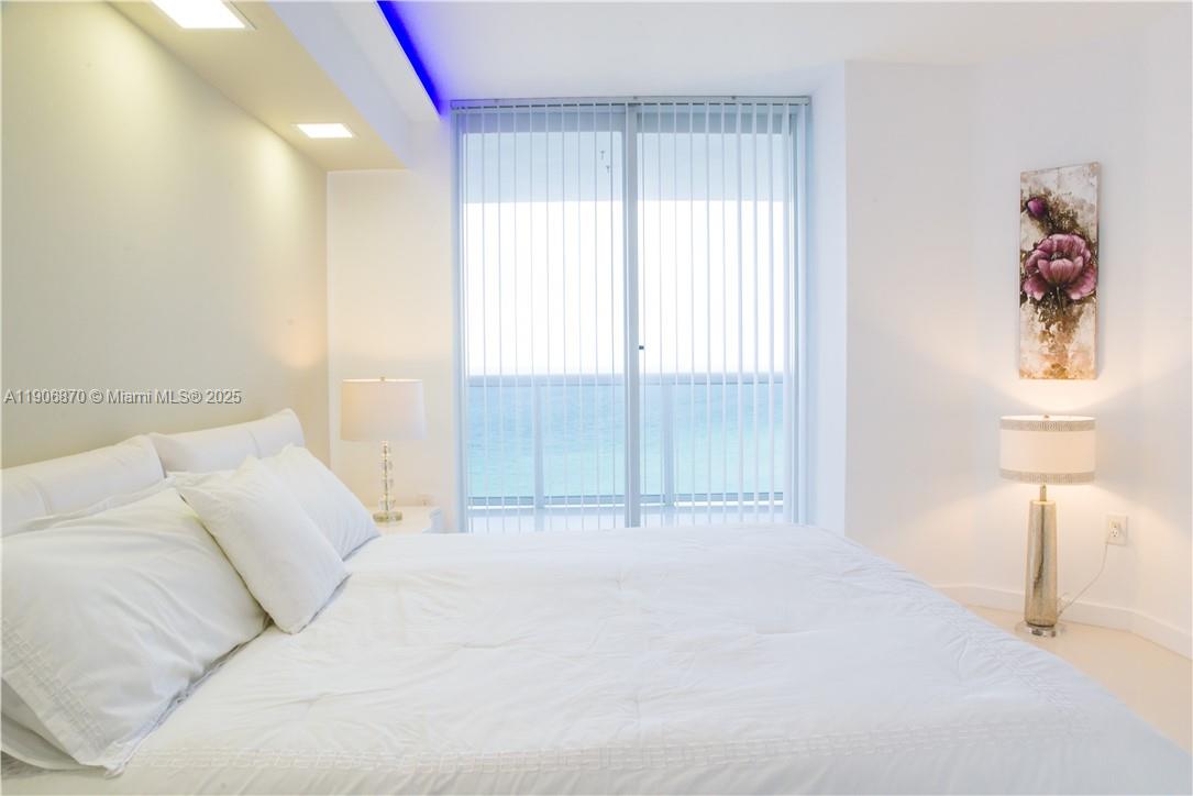 6301 Collins Avenue, Unit 1402 Miami Beach, FL 33141 - Photo 21 of 38 a bedroom with a bed and a lamp