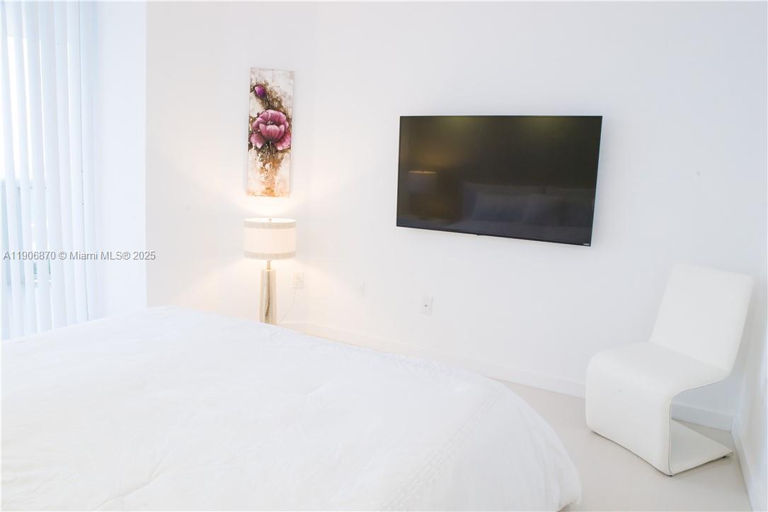 6301 Collins Avenue, Unit 1402 Miami Beach, FL 33141 - Photo 24 of 38 a living room with a flat screen tv and a white wall