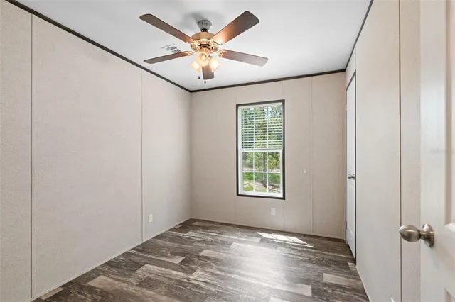 an empty room with a window and a fan