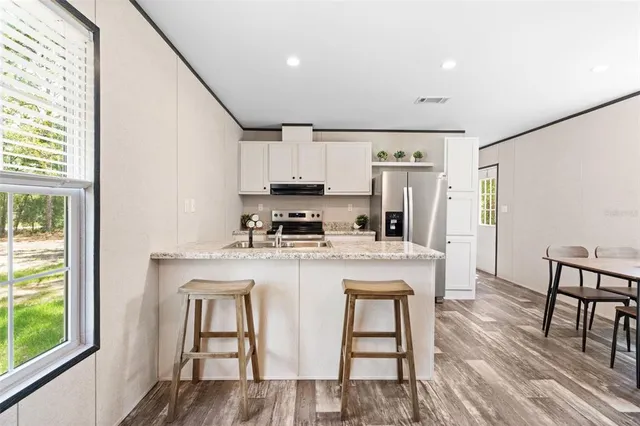 a kitchen with kitchen island a stove a table and chairs in it