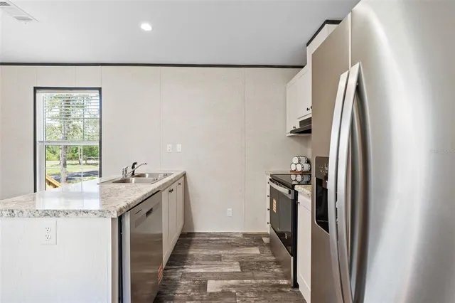 a kitchen with stainless steel appliances granite countertop a refrigerator and a sink