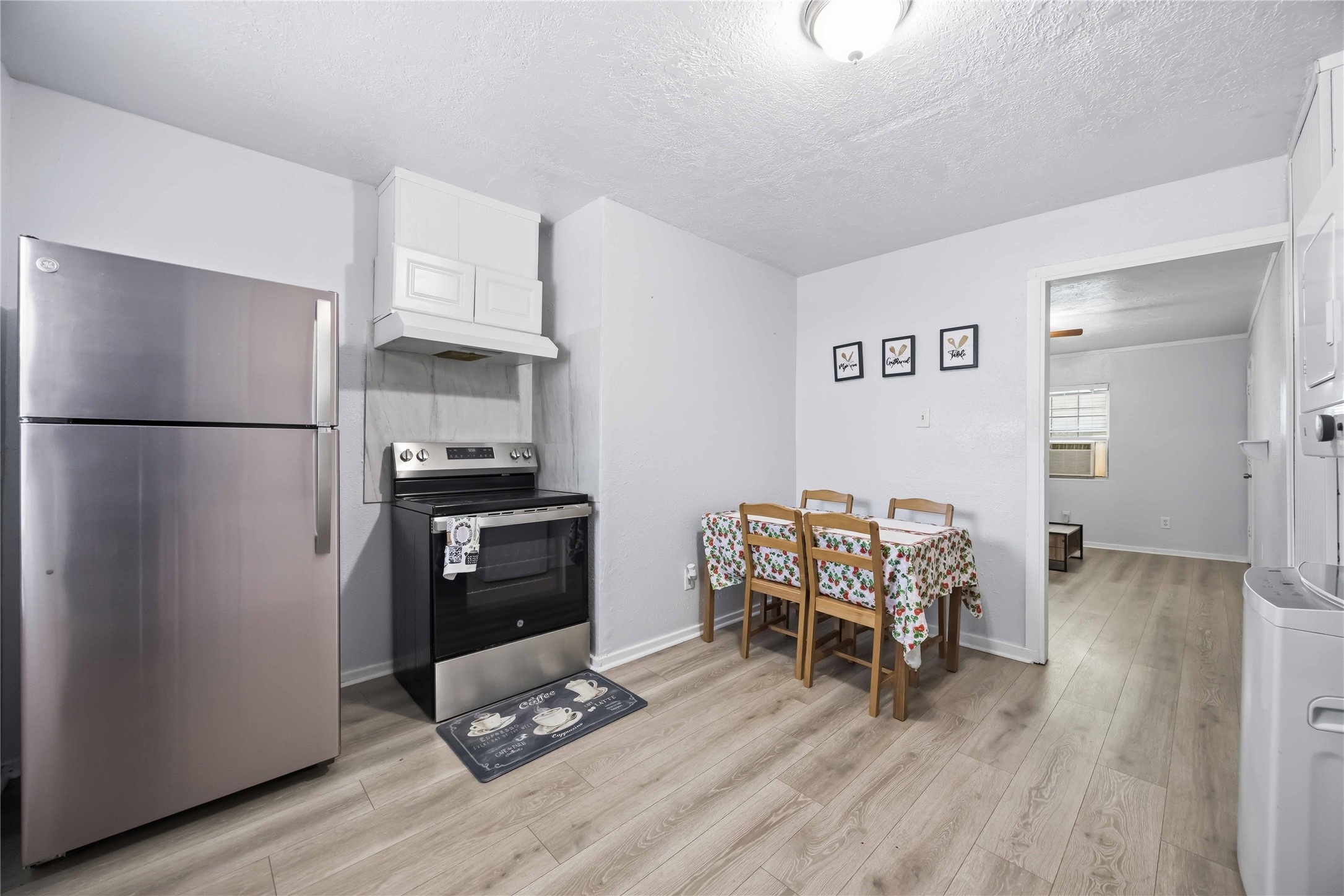 6726 Burkett Street Houston, TX 77021 - Photo 3 of 18 a kitchen with a refrigerator and a stove top oven