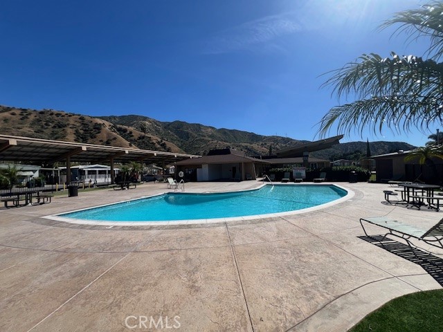 4901 Green River Road, Unit 104 Corona, CA 92878 - Photo 49 of 59 a view of a swimming pool with lawn chairs under an umbrella