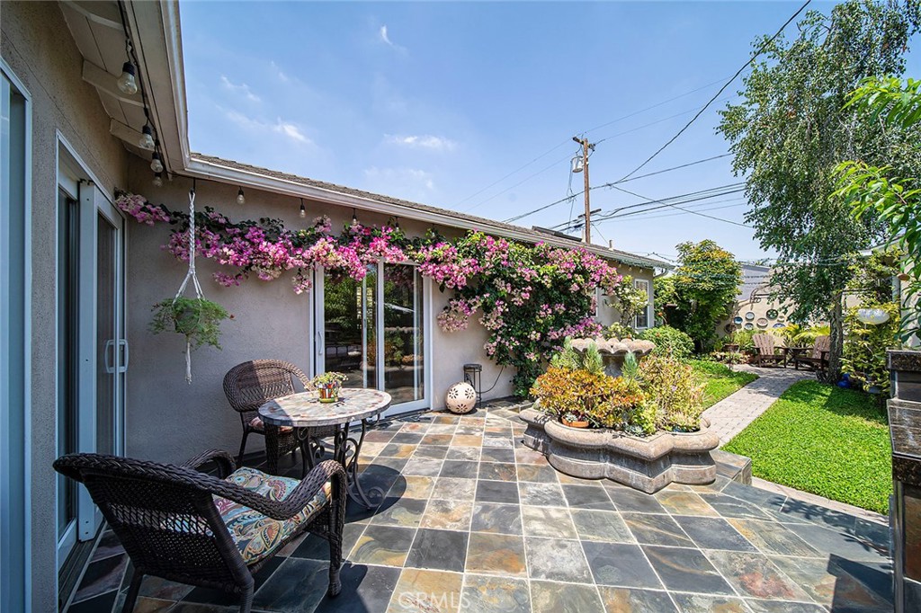 3432 Roxanne Avenue Long Beach, CA 90808 - Photo 28 of 41 a view of a patio with table and chairs potted plants and floor to ceiling window and garden