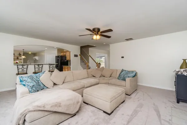 a living room with furniture and a ceiling fan