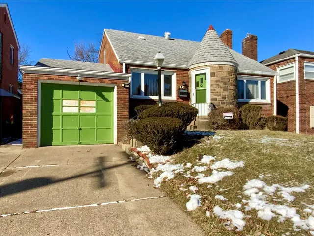 a front view of a house with a yard and a garage