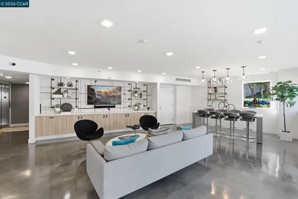a living room with furniture and view of kitchen