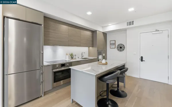 a kitchen with stainless steel appliances granite countertop a sink a refrigerator and a stove