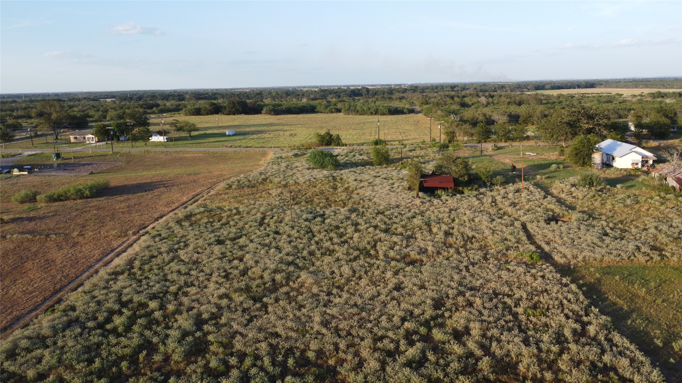6447 Gander Slough Road Kingsbury, TX 78638 - Photo 5 of 16 An aerial perspective showcases vast open acreage bordered by mature trees and natural vegetation.