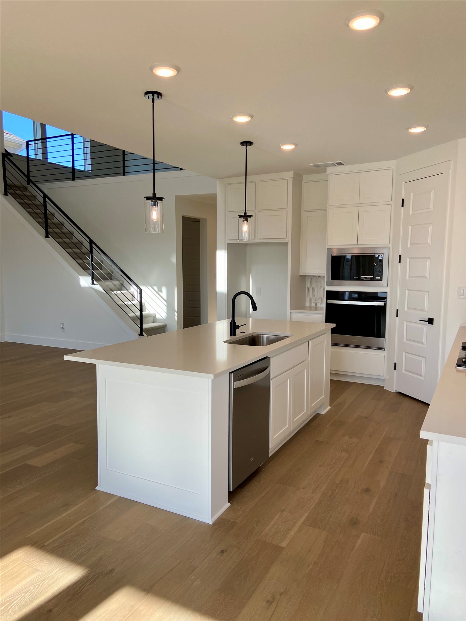 17341 Graces Path Pflugerville, TX 78660 - Photo 6 of 13 a large kitchen with stainless steel appliances kitchen island a large counter top a stove a refrigerator and a sink