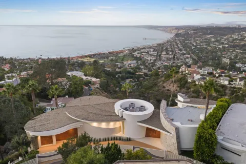 an aerial view of a house with a yard and mountain view in back