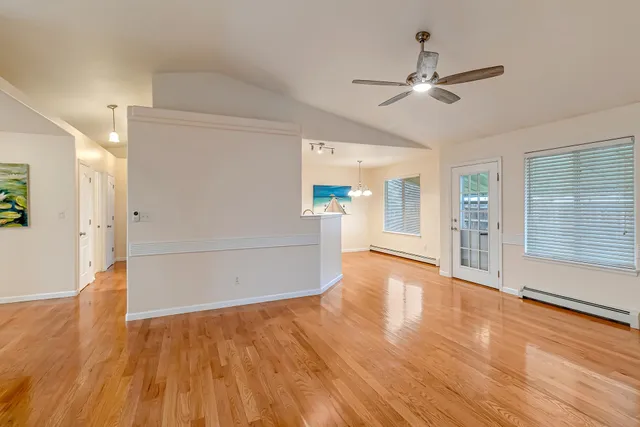 a view of a livingroom with wooden floor and a ceiling fan