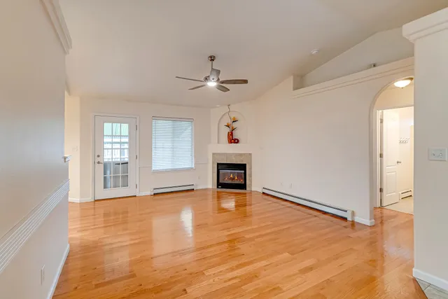 a view of an empty room with a fireplace and a window
