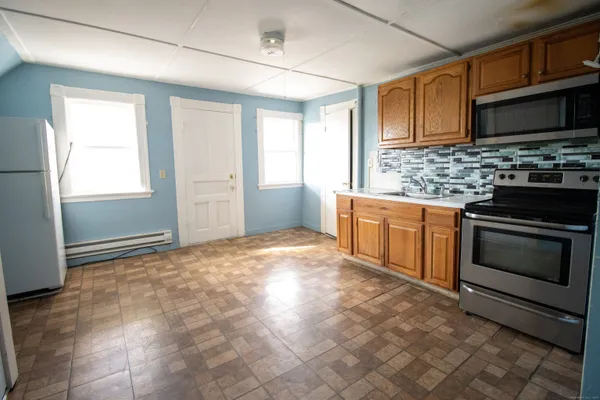 a kitchen with granite countertop a stove top oven microwave and cabinets