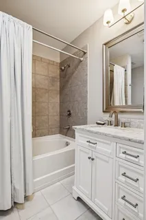 a bathroom with a tub sink and mirror
