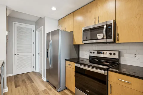 a kitchen with stainless steel appliances granite countertop a stove microwave and refrigerator