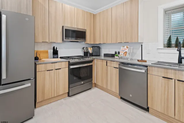 a kitchen with granite countertop white cabinets sink and stainless steel appliances