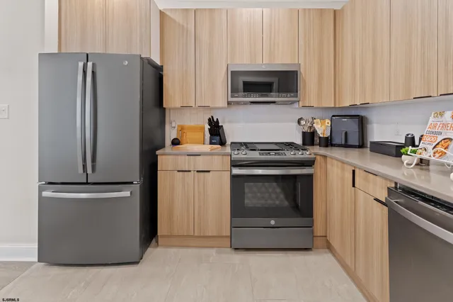 a kitchen with cabinets stainless steel appliances and a counter space