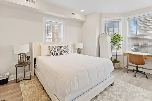 a bedroom with bed and chair with window