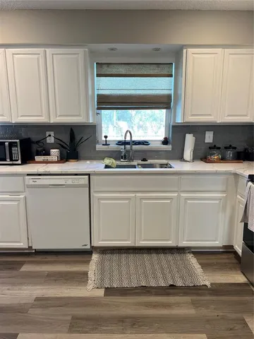 a white kitchen with granite countertop white cabinets and white appliances