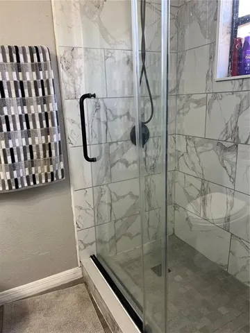 a bathroom with a toilet and a shower
