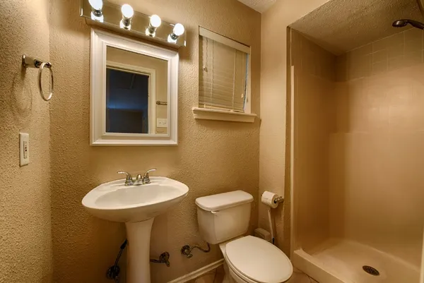 a bathroom with a sink toilet and shower