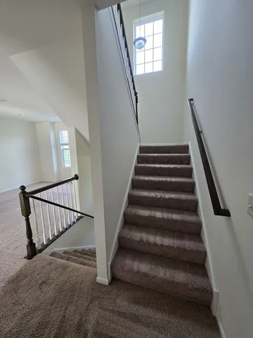 a view of staircase with lots of frames on wall