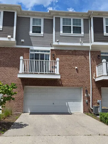 a living room with stainless steel appliances furniture a fireplace a rug and a window
