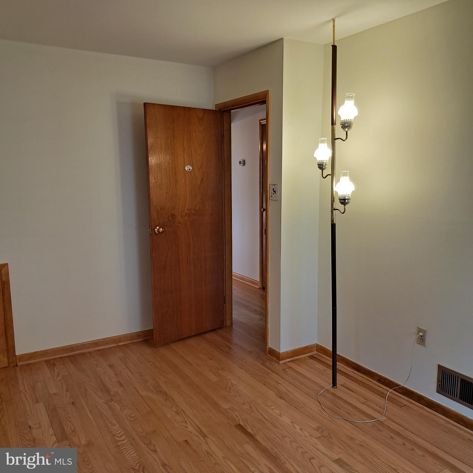 9301 Tuckerman Street Lanham, MD 20706 - Photo 23 of 48 an empty room with wooden floor and mirror