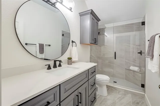 a bathroom with a sink a toilet and a mirror