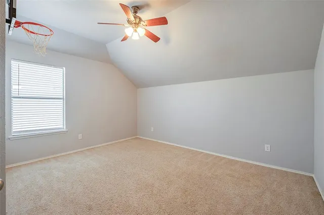 an empty room with a window and ceiling fan