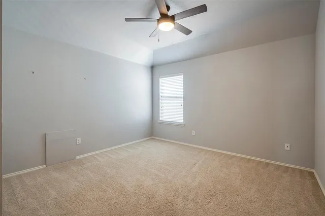 an empty room with a window and a fan
